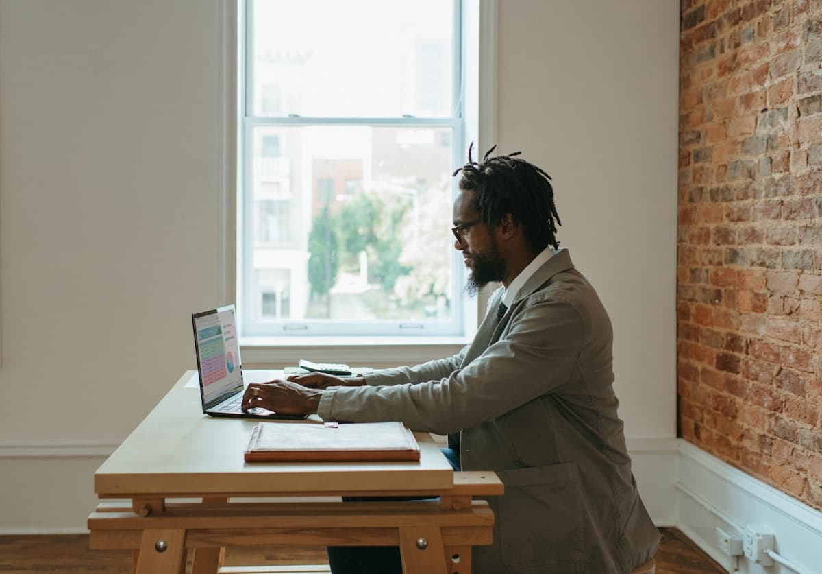 A founder working at a laptop in a sunlit office