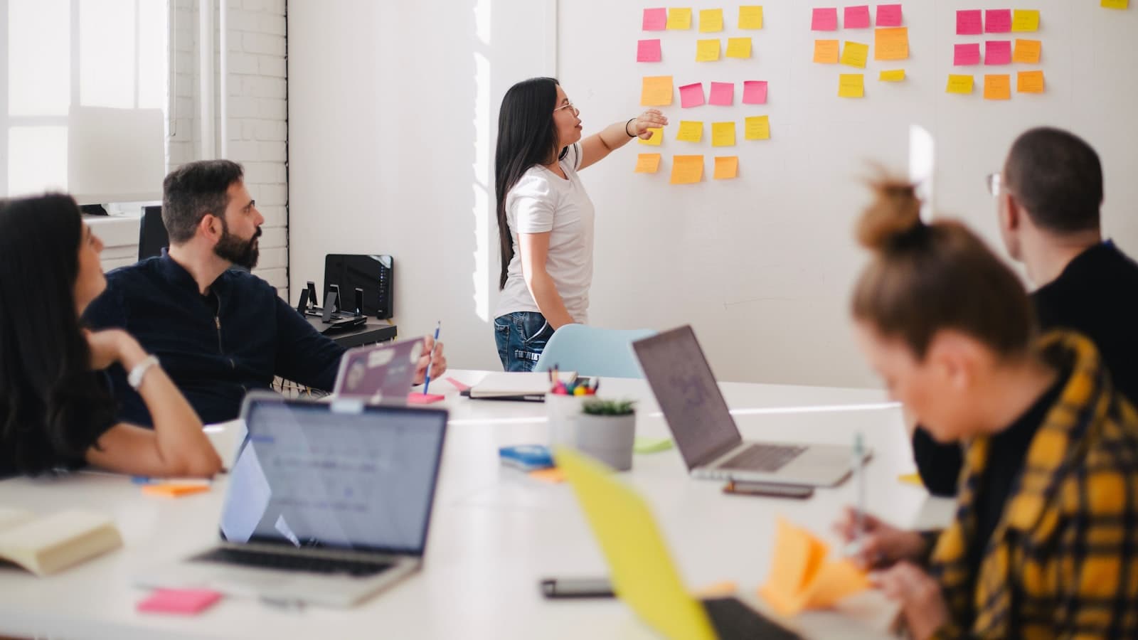 A colleague walking a seated team through a wall of notes