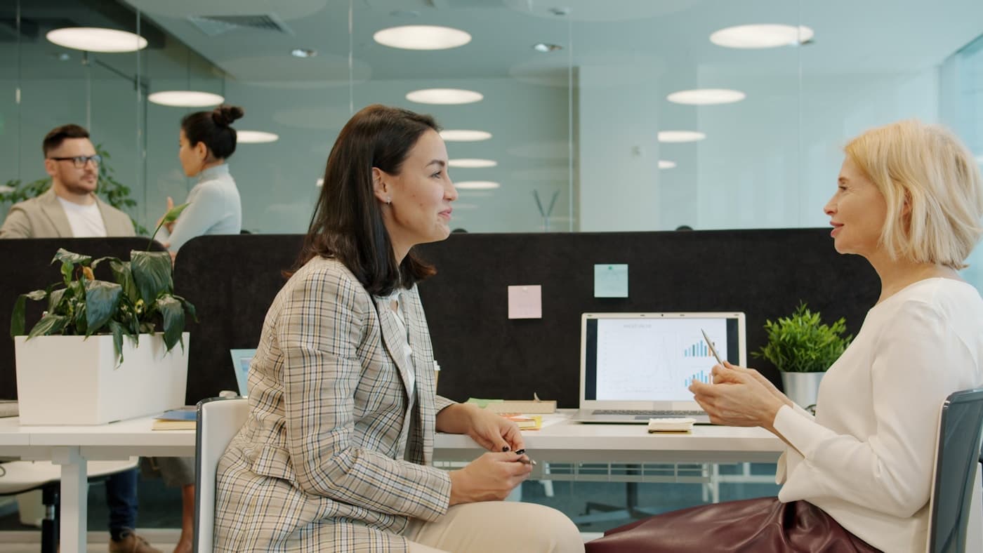 Two people talking through a decision at an office desk